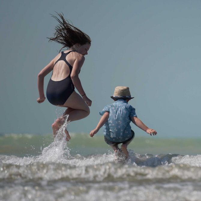 Kids jumping in the waves at Caroline Bay